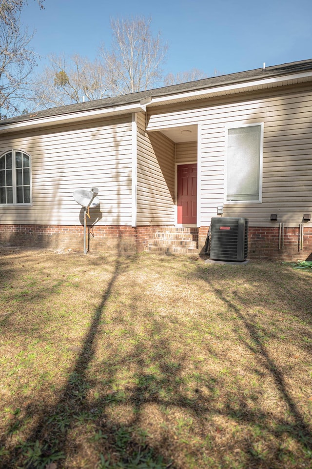 exterior space with cooling unit and a lawn