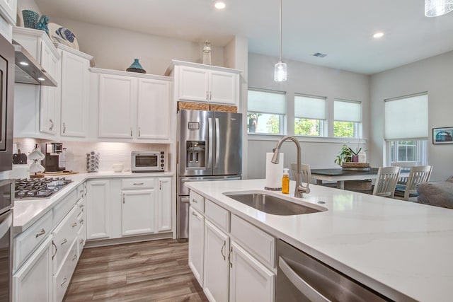 1641 Adventure Xing, Mount Pleasant, SC 29466 - kitchen with appliances with stainless steel finishes, recessed lighting, white cabinetry, light wood finished floors, and decorative backsplash
