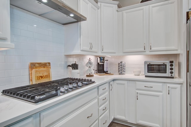 1641 Adventure Xing, Mount Pleasant, SC 29466 - kitchen featuring range hood, stainless steel gas cooktop, light countertops, white cabinetry, and backsplash