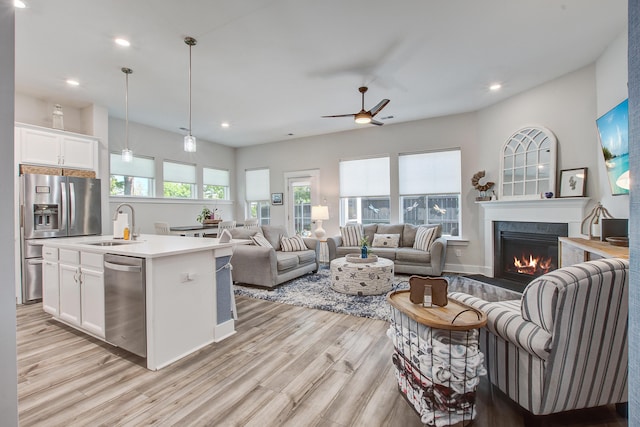 1641 Adventure Xing, Mount Pleasant, SC 29466 - kitchen with stainless steel appliances, a glass covered fireplace, light wood-style floors, white cabinets, and recessed lighting