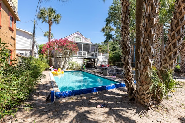 view of swimming pool with a sunroom, stairway, a fenced in pool, and a patio