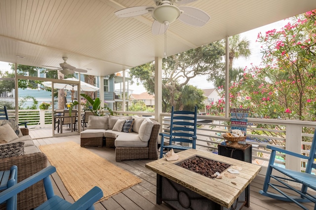 deck featuring outdoor dining area, a ceiling fan, and an outdoor living space with a fire pit