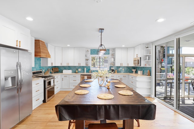 kitchen with light countertops, open shelves, premium range hood, and stainless steel appliances