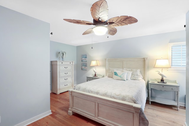 bedroom featuring baseboards, a ceiling fan, and light wood finished floors
