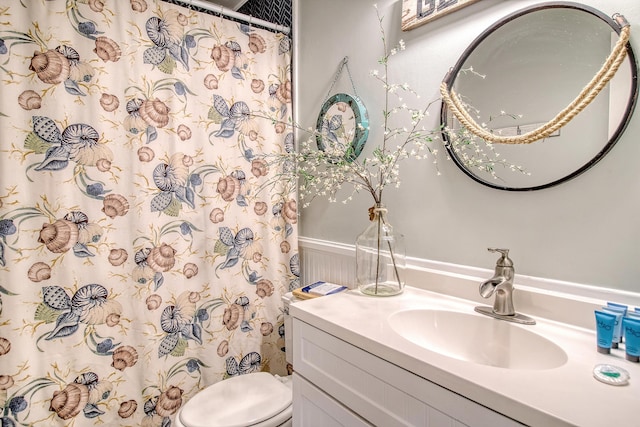 bathroom with vanity, a shower with shower curtain, and toilet