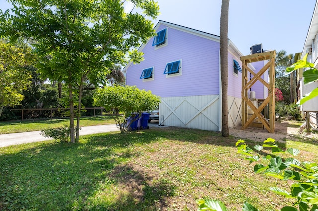 view of side of home featuring a yard and cooling unit