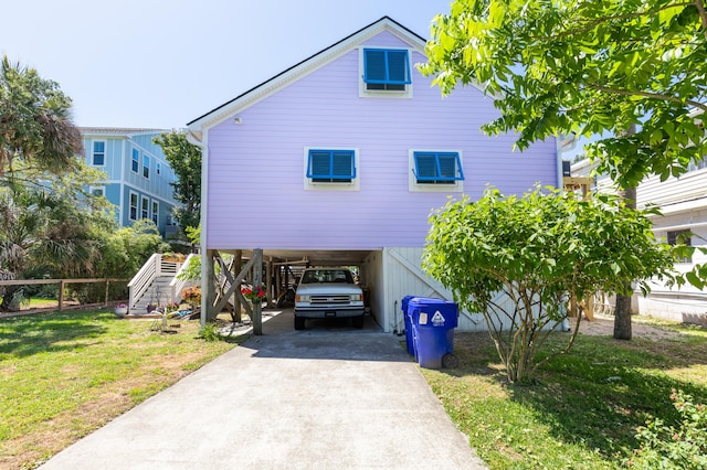 view of front of house featuring driveway, stairs, a front yard, and a carport