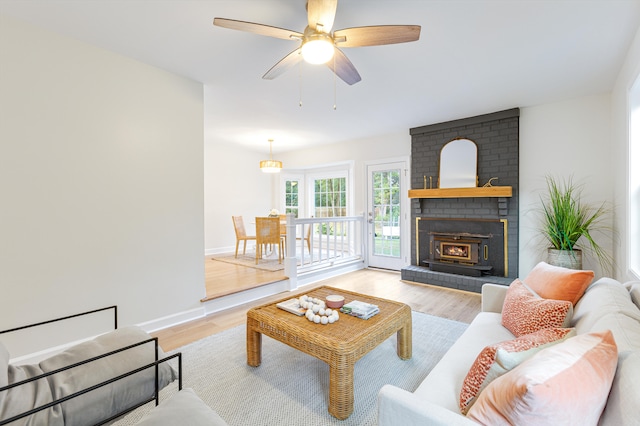 living room with a fireplace, light hardwood / wood-style floors, and ceiling fan