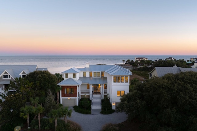 view of front of property featuring a garage and a water view