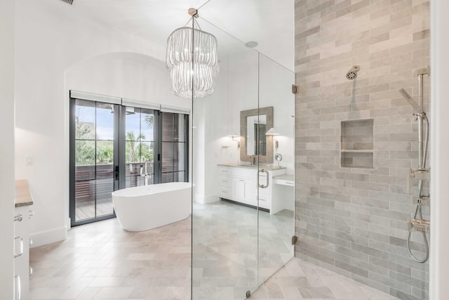 bathroom featuring vanity, an inviting chandelier, shower with separate bathtub, and french doors