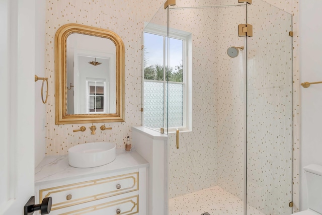 bathroom with vanity, toilet, and tiled shower