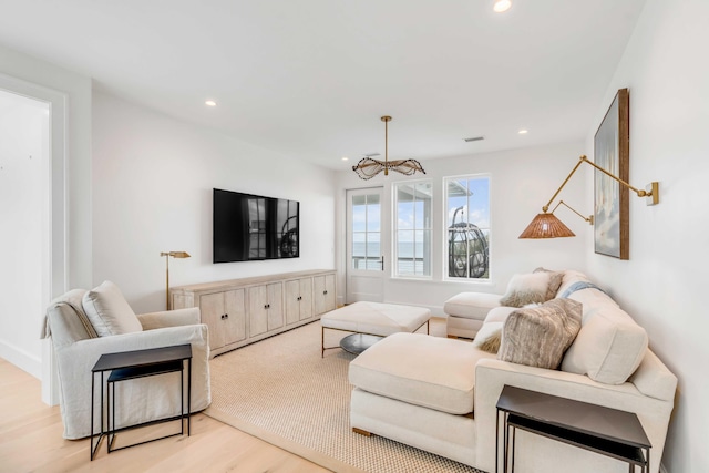 living room featuring a chandelier and light wood-type flooring