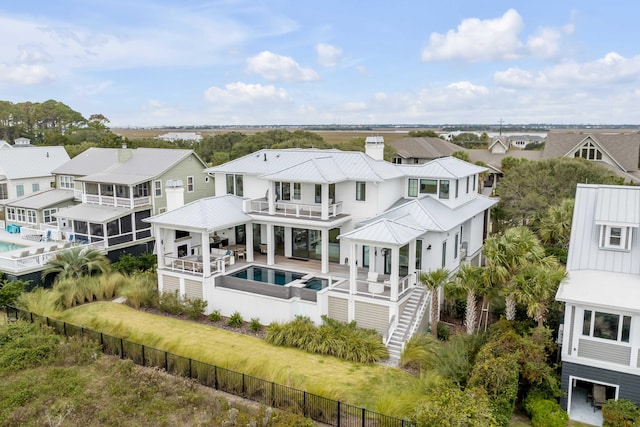 back of house featuring a fenced in pool and a balcony