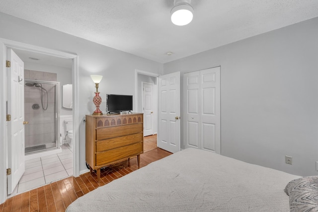 bedroom featuring a closet, baseboards, connected bathroom, and wood finished floors