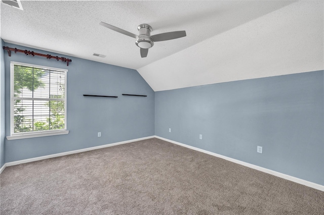 additional living space with vaulted ceiling, carpet, a ceiling fan, and visible vents