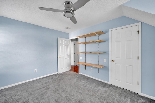 unfurnished bedroom featuring baseboards, carpet, a ceiling fan, and a textured ceiling