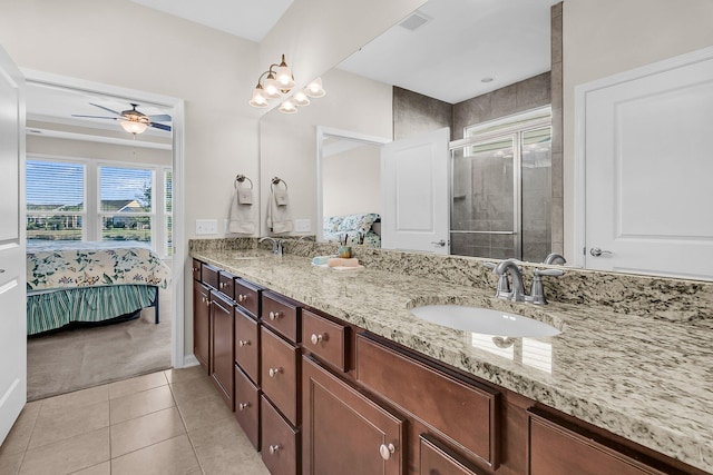 bathroom featuring tile patterned flooring, vanity, ceiling fan, and an enclosed shower