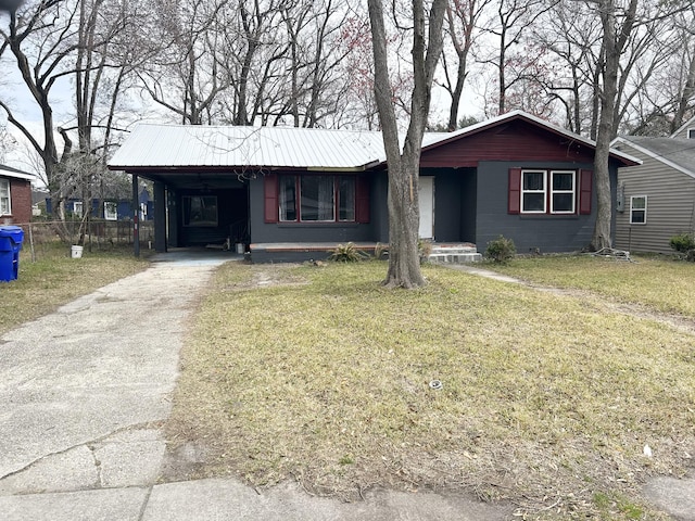 ranch-style home with metal roof, aphalt driveway, a carport, and a front yard