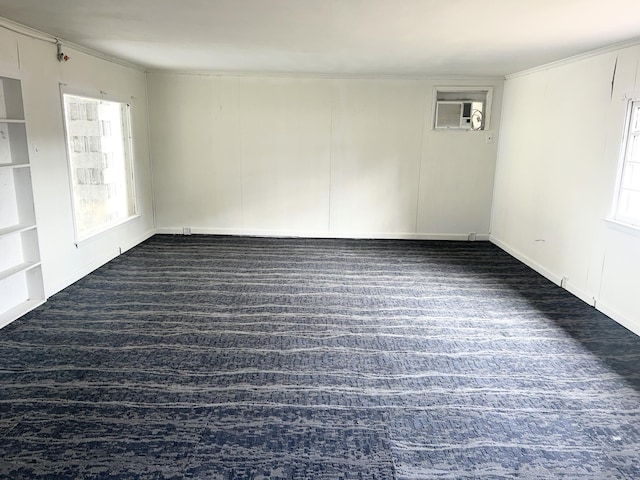 spare room with a healthy amount of sunlight, dark wood-type flooring, and an AC wall unit