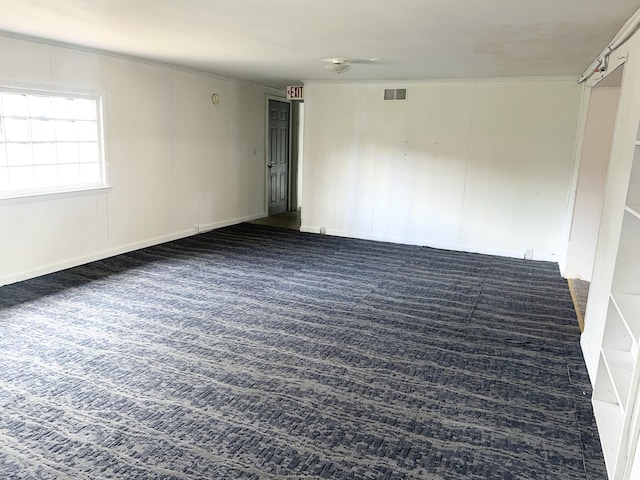 empty room featuring dark carpet and visible vents