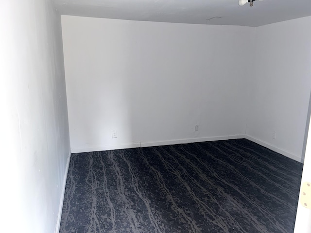 spare room with baseboards