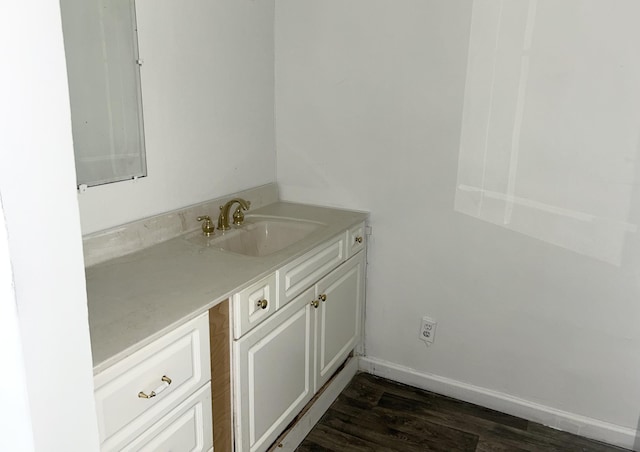 bathroom with baseboards, wood finished floors, and vanity