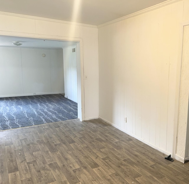 unfurnished room featuring ornamental molding, wood finished floors, and visible vents