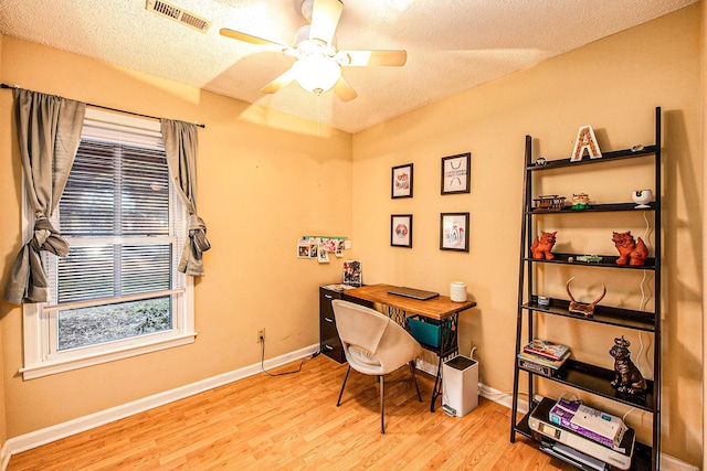 office with ceiling fan, a textured ceiling, and light wood-type flooring