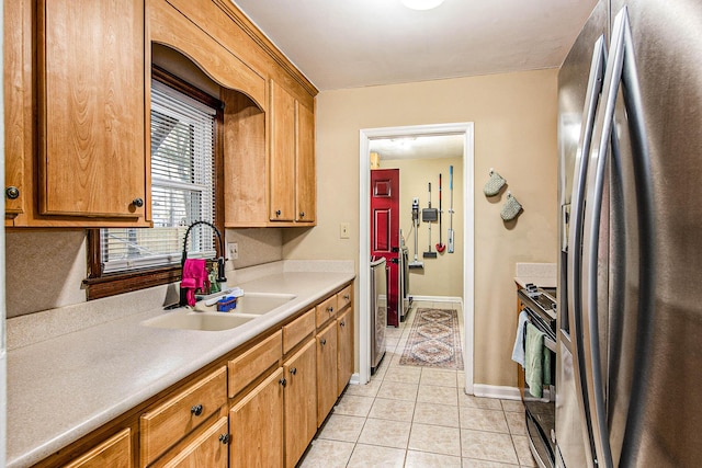 kitchen with sink, light tile patterned floors, and appliances with stainless steel finishes