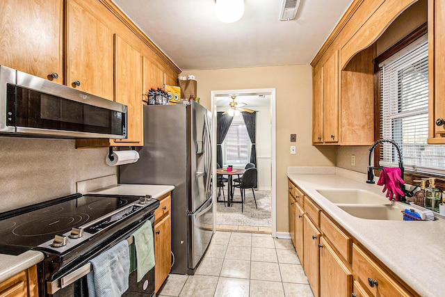 kitchen with light tile patterned flooring, ceiling fan, sink, and range with electric stovetop