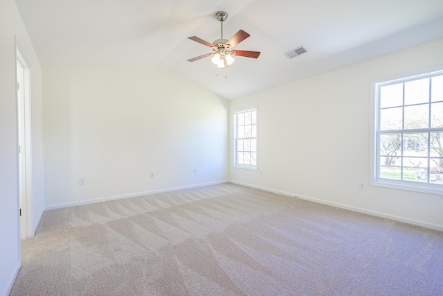 empty room with vaulted ceiling, baseboards, visible vents, and light carpet