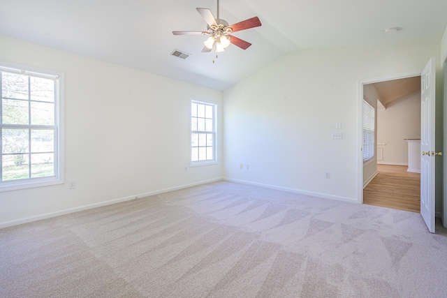 carpeted spare room with baseboards, visible vents, a ceiling fan, and lofted ceiling