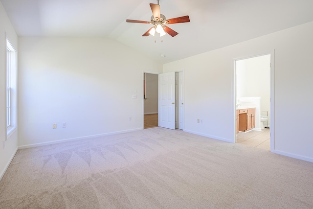 unfurnished room with light colored carpet, baseboards, lofted ceiling, and ceiling fan