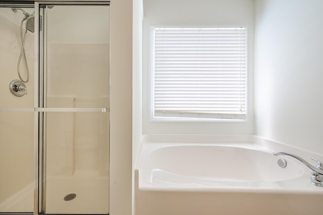 bathroom with a bath and a shower stall