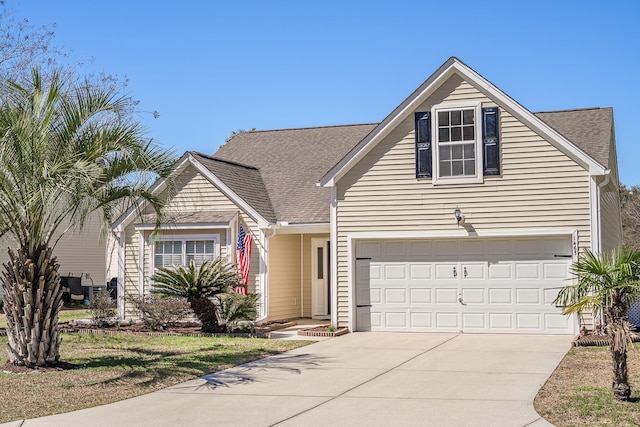 traditional-style home with a garage, driveway, and a shingled roof