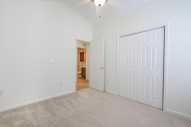 unfurnished bedroom with a ceiling fan, baseboards, lofted ceiling, a closet, and carpet flooring