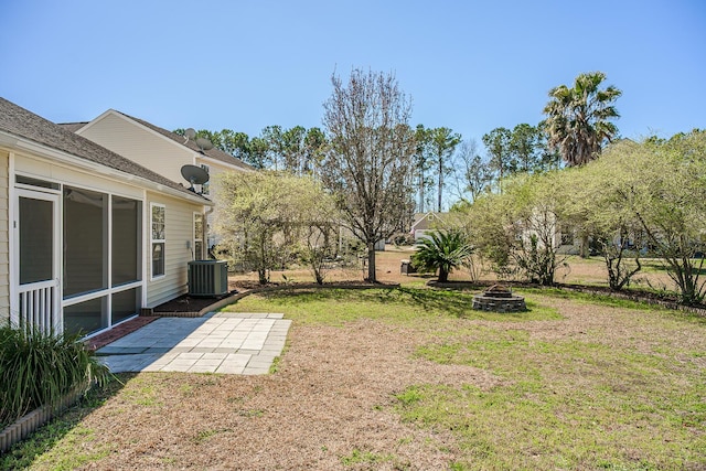 view of yard with a patio area, cooling unit, a fire pit, and a sunroom