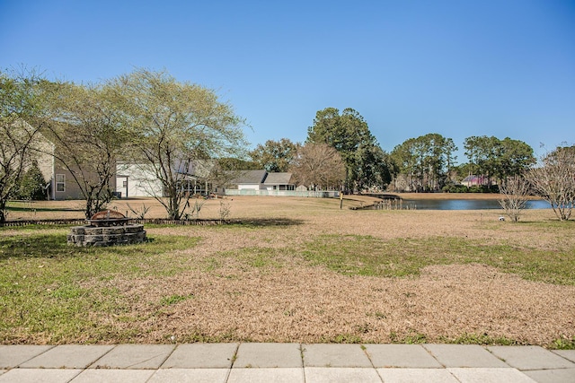 view of yard with a water view and an outdoor fire pit