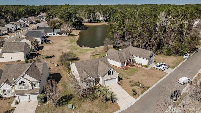 drone / aerial view with a forest view, a residential view, and a water view