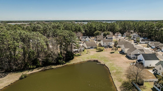 bird's eye view featuring a residential view, a wooded view, and a water view