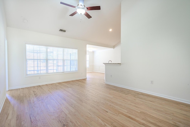 unfurnished room featuring light wood-type flooring, visible vents, baseboards, ceiling fan, and vaulted ceiling