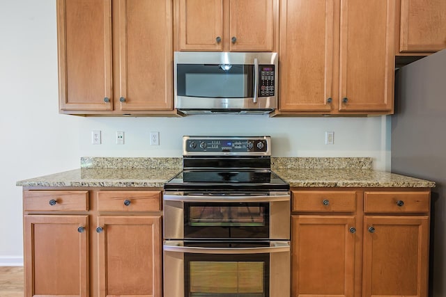 kitchen featuring light stone counters and appliances with stainless steel finishes