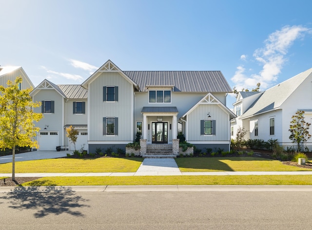 modern farmhouse style home with french doors, a garage, and a front lawn