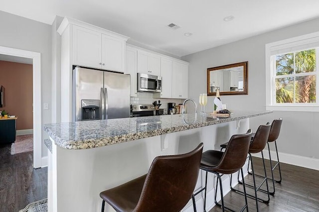 162 Spring St, Charleston, SC 29403 - kitchen with appliances with stainless steel finishes, dark wood-style floors, white cabinetry, baseboards, and recessed lighting