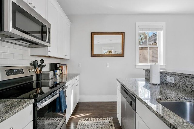 162 Spring St, Charleston, SC 29403 - kitchen with stainless steel appliances, baseboards, dark wood-style flooring, decorative backsplash, and white cabinetry