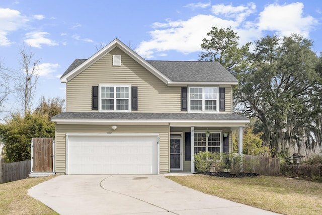 traditional home with concrete driveway, an attached garage, fence, and a front yard