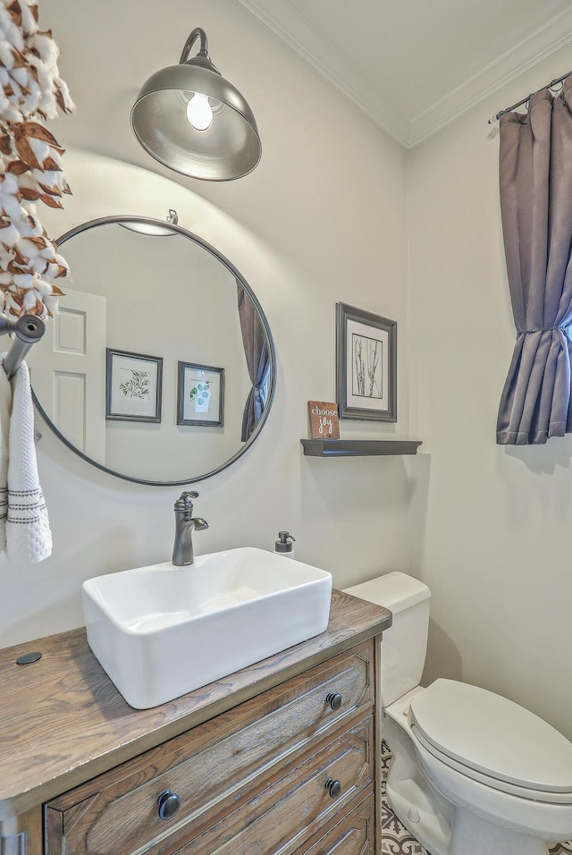 bathroom featuring ornamental molding, vanity, and toilet