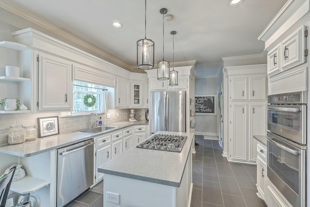 kitchen with sink, hanging light fixtures, stainless steel appliances, white cabinets, and a kitchen island