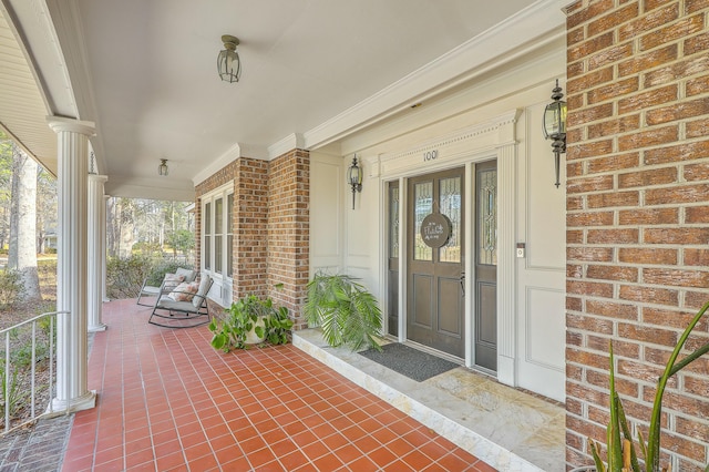 view of exterior entry featuring covered porch