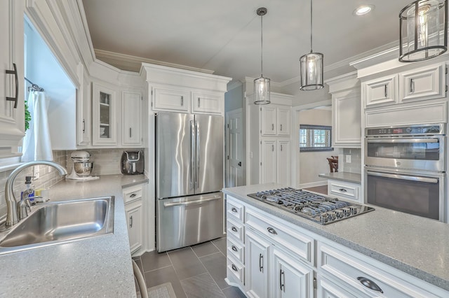 kitchen featuring white cabinetry, appliances with stainless steel finishes, decorative light fixtures, and sink